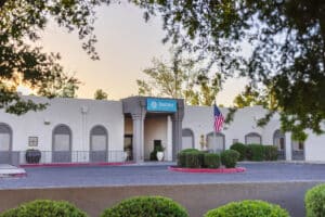 Front driveway view of building and flag at Ahwatukee Post Acute